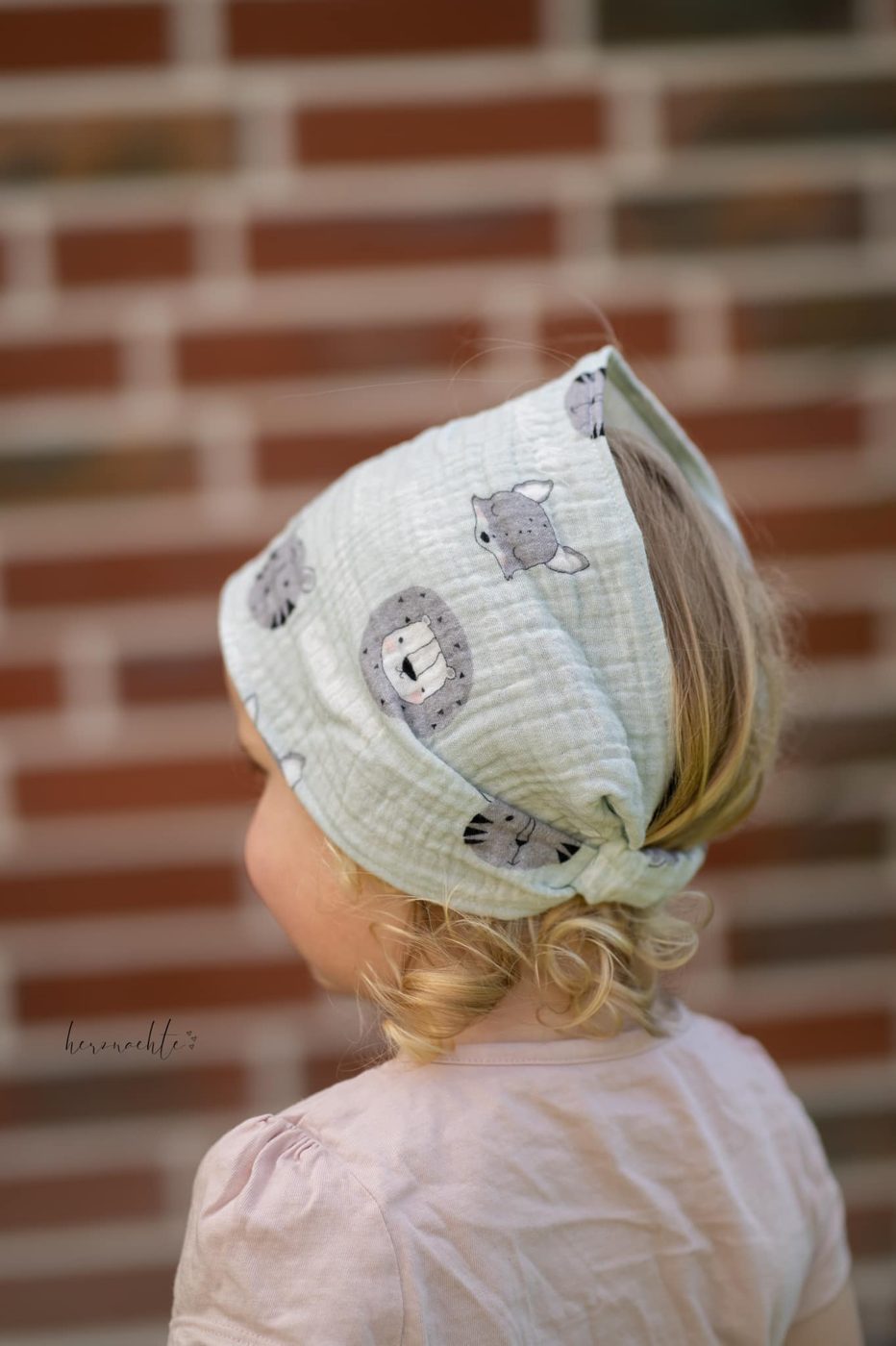 Child wearing a handmade muslin head scarf
